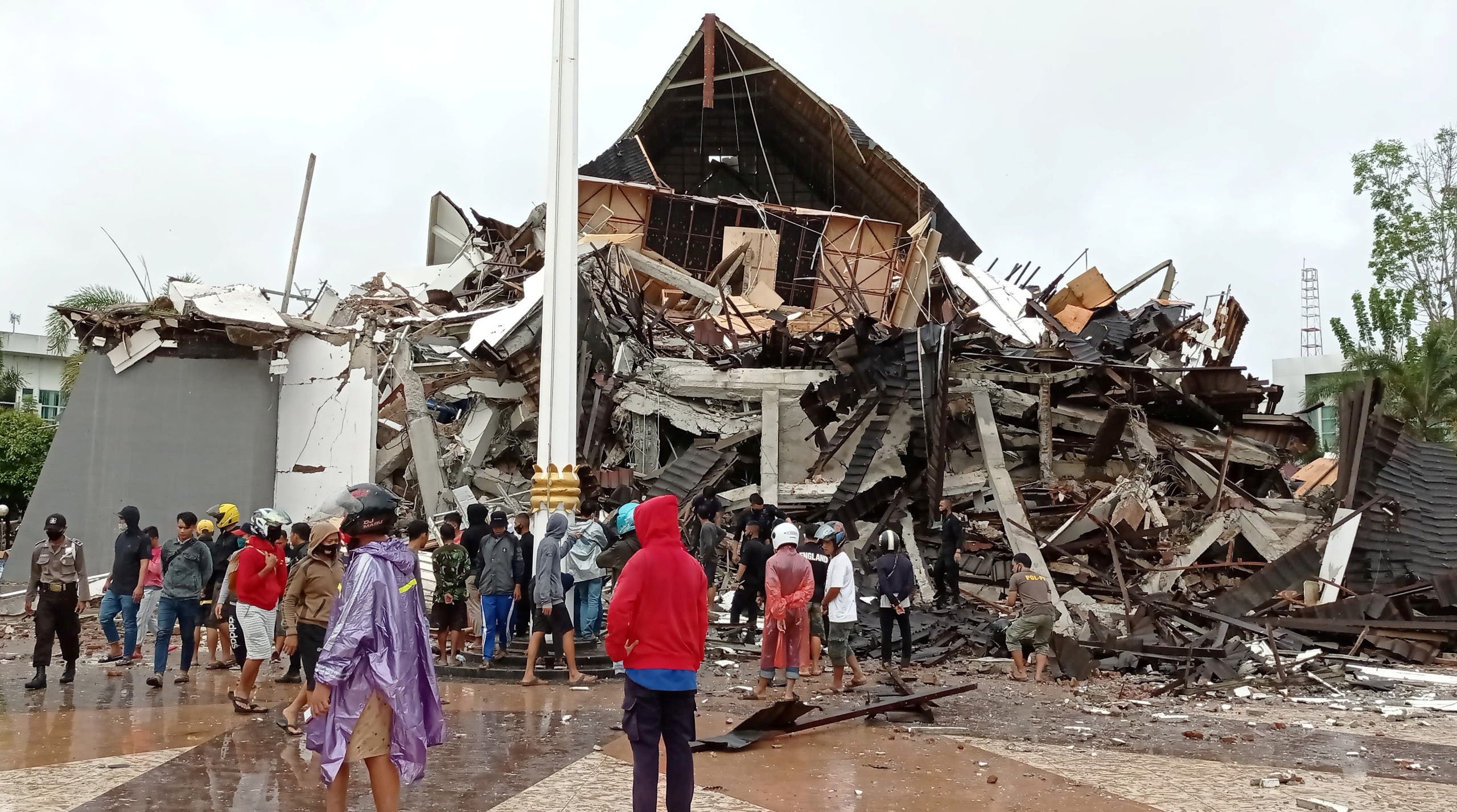 People look at the damaged province's office of governor of West Sulawesi following an earthquake in Mamuju. (Reuters)