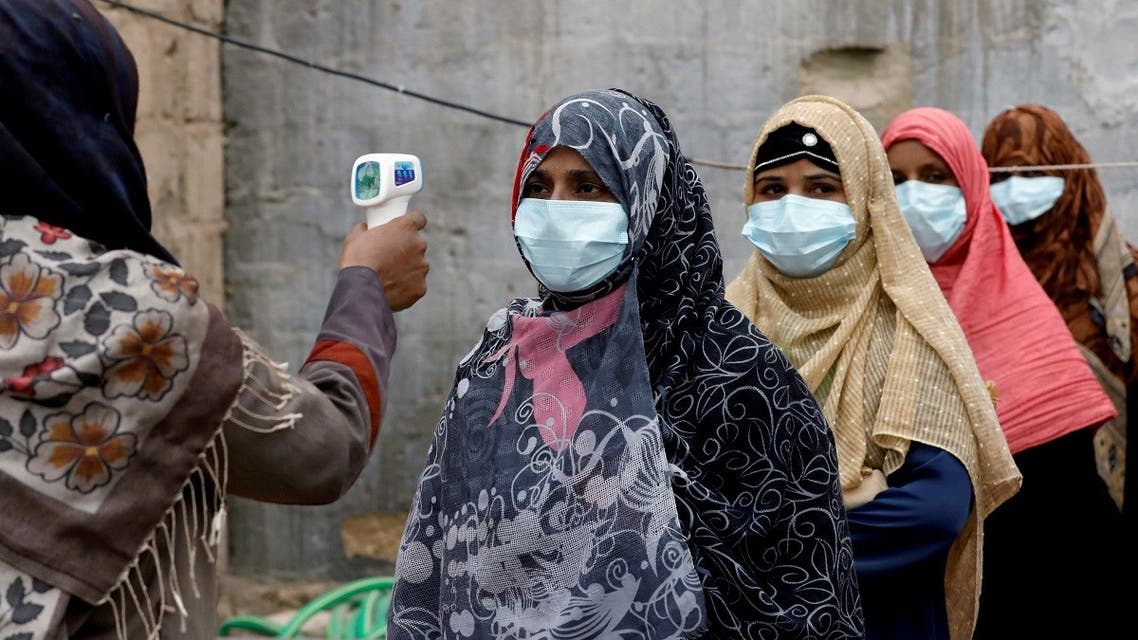 A file photo shows vaccinators wear protective masks as they get their temperature checked, during an anti-polio campaign, in a low-income neighborhood as the spread of the coronavirus continues, in Karachi, Pakistan, July 20, 2020. (Reuters/Akhtar Soomro)
