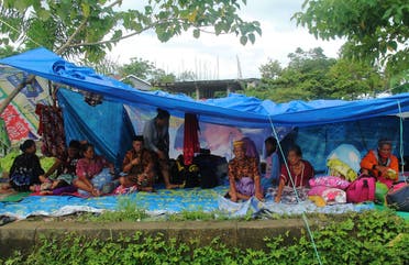 Locals who fled to higher ground are seen at a temporary shelter following an earthquake in Mamuju. (Reuters)