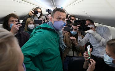  Alexei Navalny is surrounded by journalists inside the plane prior to his flight to Moscow in the Airport Berlin Brandenburg (BER) in Schoenefeld, near Berlin, Germany, Sunday, Jan. 17, 2021. Leading Kremlin critic Alexei Navalny plans to fly home to Russia on Sunday after recovering in Germany from his poisoning in August with a nerve agent. (AP Photo/Mstyslav Chernov)