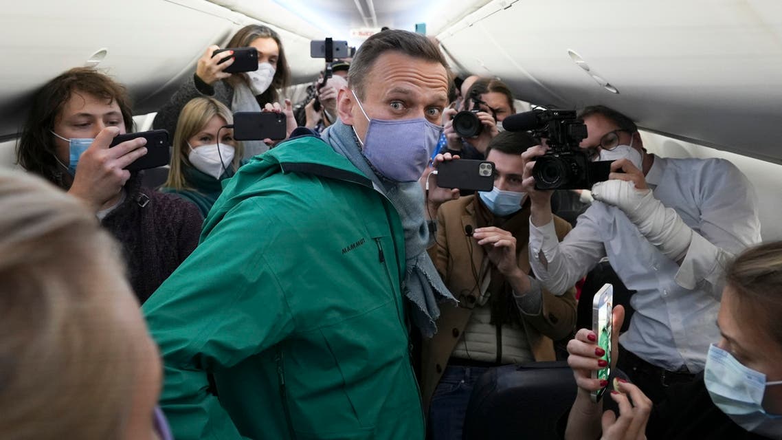 Alexei Navalny is surrounded by journalists inside the plane prior to his flight to Moscow in the Airport Berlin Brandenburg (BER) in Schoenefeld, near Berlin, Germany, Sunday, Jan. 17, 2021. Leading Kremlin critic Alexei Navalny plans to fly home to Russia on Sunday after recovering in Germany from his poisoning in August with a nerve agent. (AP Photo/Mstyslav Chernov)