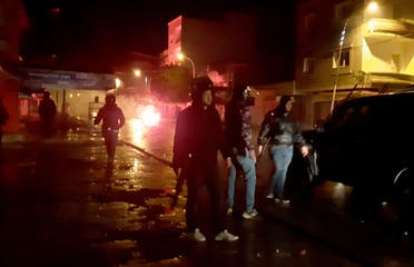 Police officers face demonstrators during clashes in Siliana, Tunisia, Saturday, Jan.16, 2021. Police used tear gas to disperse violent protests led by disgruntled youths in several Tunisian cities Saturday night to Sunday, including in the capital Tunis and the seaside city of Sousse. (AP)
