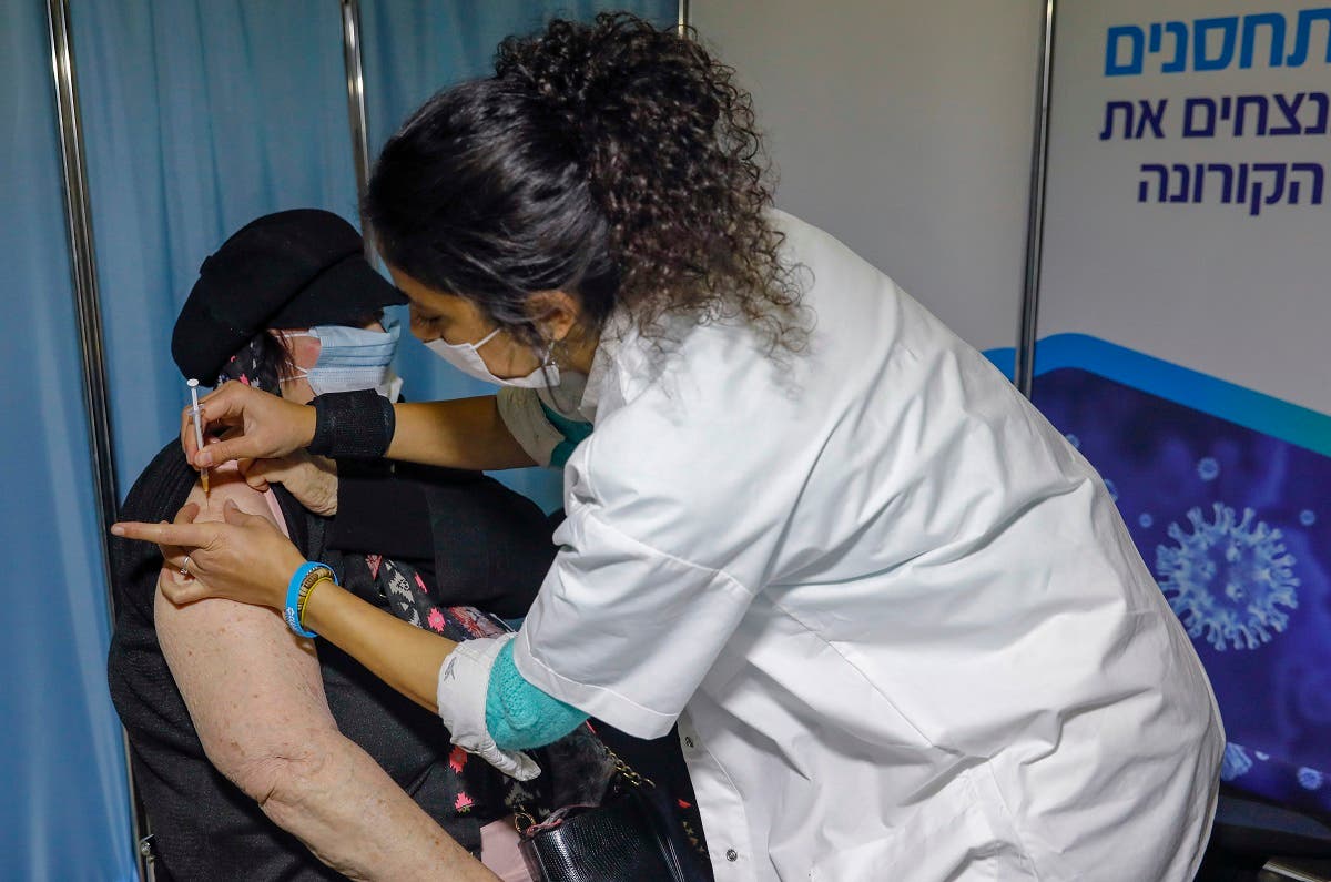 An Israeli healthcare worker administers a COVID-19 vaccine to a woman at the Kupat Holim Clalit clinic in Jerusalem. (File photo: AFP)