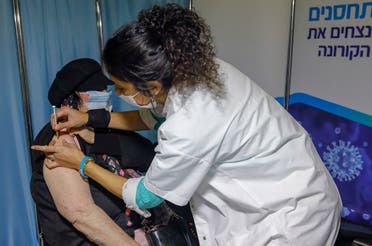 In this file photo taken on January 14, 2021, an Israeli healthcare worker administers a COVID-19 vaccine to a woman at the Kupat Holim Clalit clinic in Jerusalem. (Ahmad Gharabli/AFP)