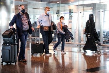 مسافرون في مطار الدوحة يستعدون لركوب أول رحلة للقاهرة بعد عودة الطيران بين البلدين في 18 يناير