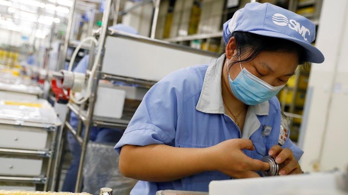 An employee wearing a face mask works at a factory of the component maker SMC during a government organized tour of its facility following the outbreak of the coronavirus in Beijing, China, on May 13, 2020. (Reuters)