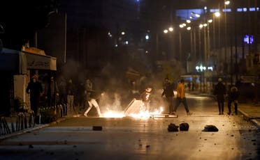 Protesters block a street during clashes with security forces in the Ettadhamen city suburb on the northwestwern outskirts of Tunisia's capital Tunis on January 17, 2021, amidst a wave of nightly protests in the North African country. (AFP)