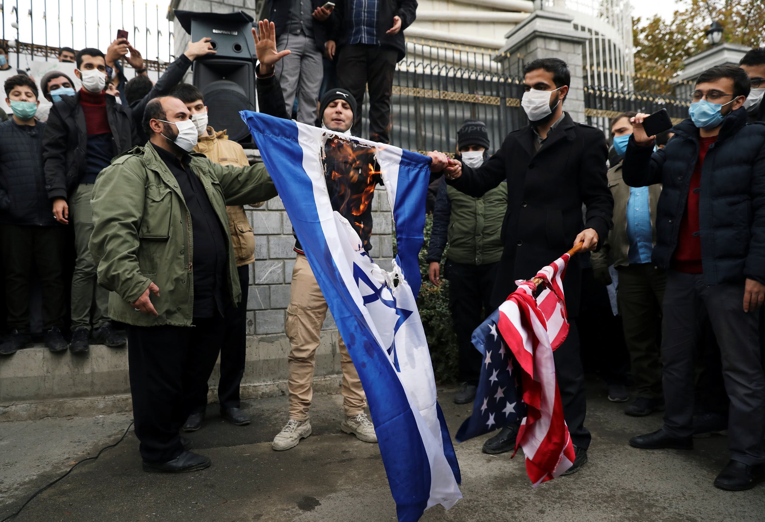 إيرانيون يحرقو علمي إسرائيل والولايات المتحدة في طهران في نوفمبر الماضي عقب مقتل عالم نويي كبير