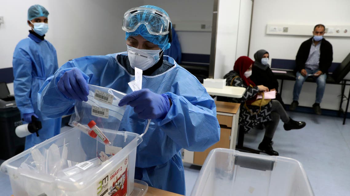 A nurse in protective clothing holds coronavirus testing material, at a center in the Rafik Hariri University Hospital in Beirut on Jan. 11, 2021. (AP)