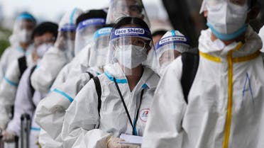 Foreign passengers wearing protective suits line up for their flight to China at Manila's International Airport, Philippines. (AP)