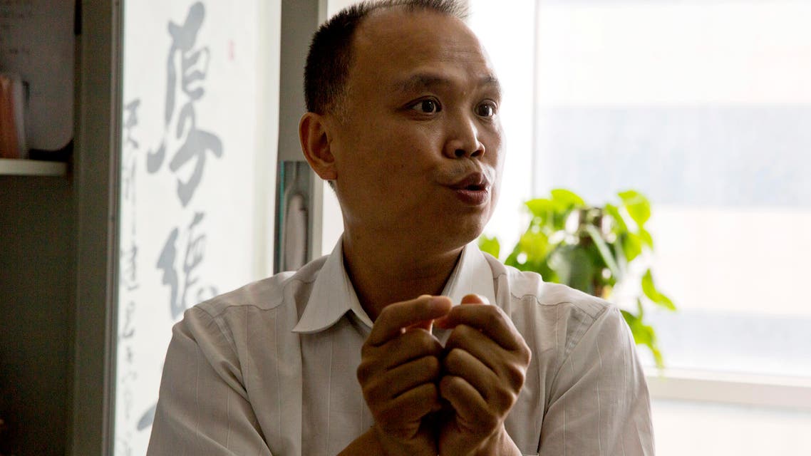 In this Thursday, July 23, 2015 photo, Chinese lawyer Yu Wensheng holds up his hands to show how death row prisoners are handcuffed 24 hours a day during an interview at his office in Beijing. Chinese lawyer who spoke up on behalf of rights lawyers persecuted by authorities was himself taken away by police in handcuffs, his wife said Friday, Aug. 7. (AP Photo/Ng Han Guan)