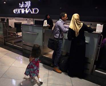 A file photo shows passengers check into a flight at Abu Dhabi International Airport in Abu Dhabi, United Arab Emirates, July 4, 2017. (AP/Jon Gambrell)