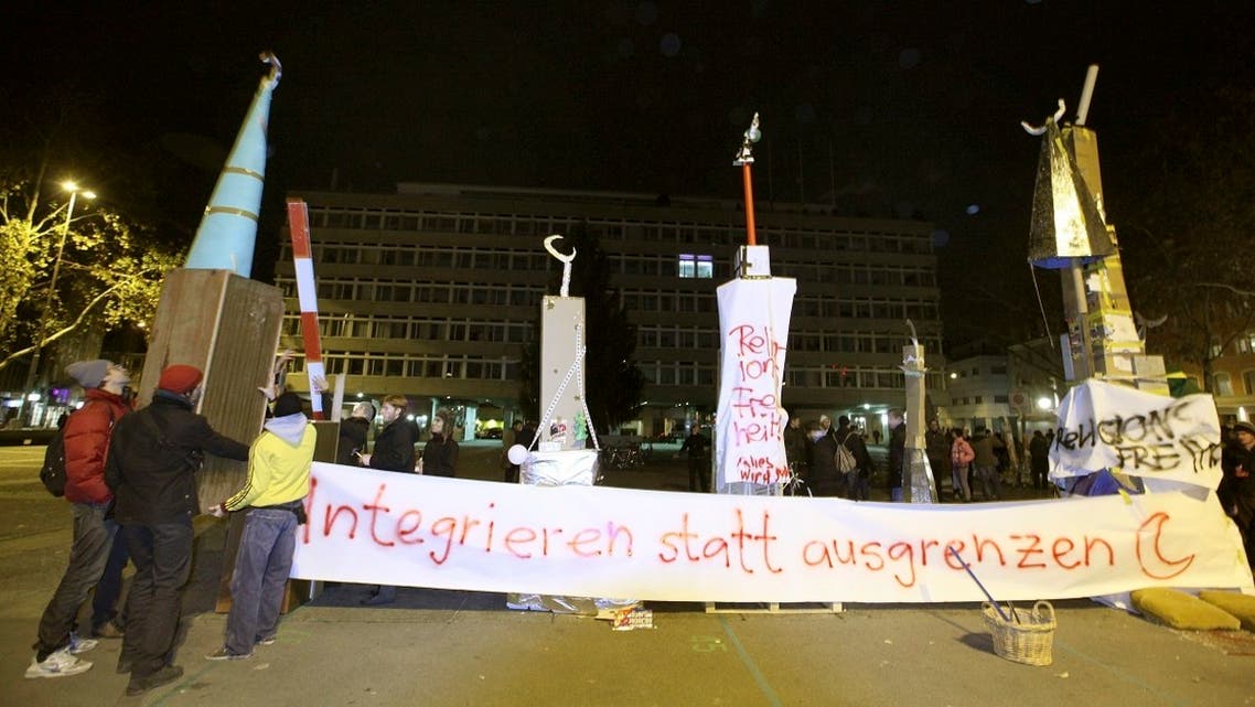 Protesters erect symbolic minarets to protest against the results of a vote in Switzerland at the Helvetiaplatz square in Zurich, on November 29, 2009. Switzerland voted to ban the construction of new minarets. The banner reads ‘Integrate instead of segregate.’ (Reuters)