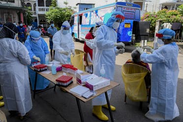 Health workers collect a swab sample from a resident to test for the COVID-19 coronavirus in Colombo, Sri Lanka on January 4, 2021. (Ishara S. Kodikara/AFP)