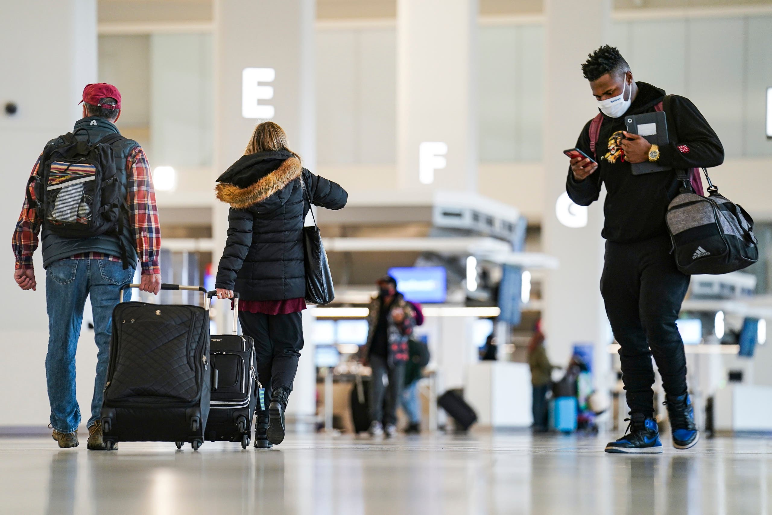 Travelers wearing protective masks to prevent the spread of COVID-19 arrive in Terminal C at LaGuardia Airport. (AP)