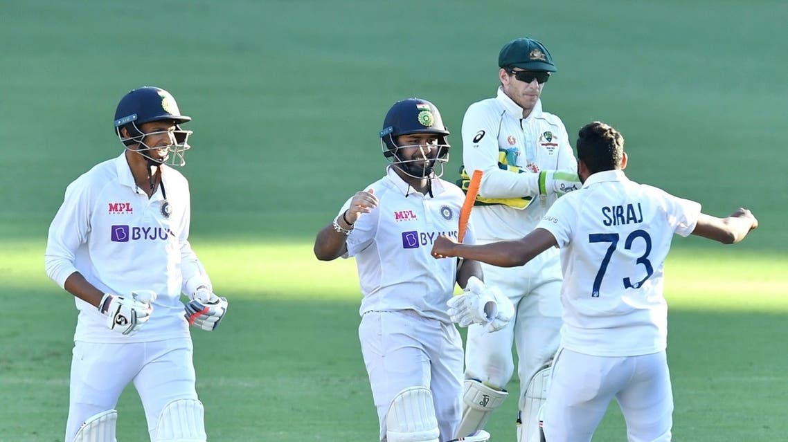 Rishabh Pant of India celebrates with teammates Navdeep Saini and Mohammed Siraj past Australia's captain Tim Paine after winning on day five of the fourth test match between Australia and India at the Gabba in Brisbane, Australia, on January 19, 2021. (Reuters)