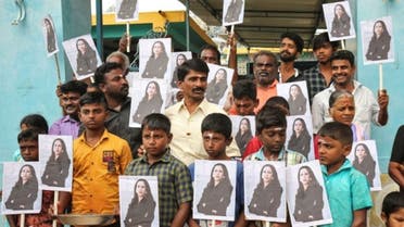 People holding placards with the photo of Vice President-elect Kamala Harris celebrate on the day of her inauguration in the village of Thulasendrapuram, where Harris' maternal grandfather was born and grew up, in the southern Indian state of Tamil Nadu, India, January 20, 2021. (Reuters)