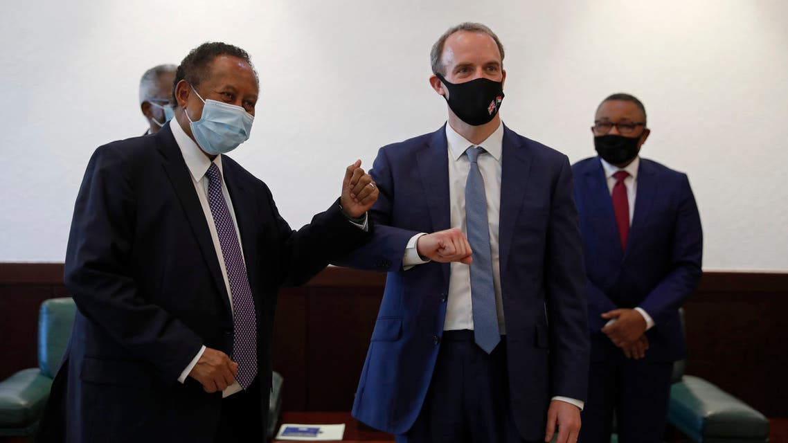 Sudanese Prime MInister Abdullah Hamdok, right, bumps elbows with British Foreign Secretary, Dominic Raab in the Cabinet Building, in Khartoum, Sudan on Jan. 21, 2021. (AP)