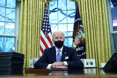 US President Joe Biden wearing a protective face mask signs executive orders in the Oval Office of the White House in Washington, Jan. 20, 2021. (Reuters)