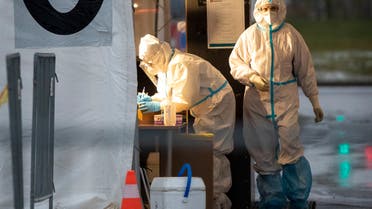 Medical workers prepare to take swab samples testing for the coronavirus, at a mobile coronavirus test station in Vilnius, Lithuania. (AP)