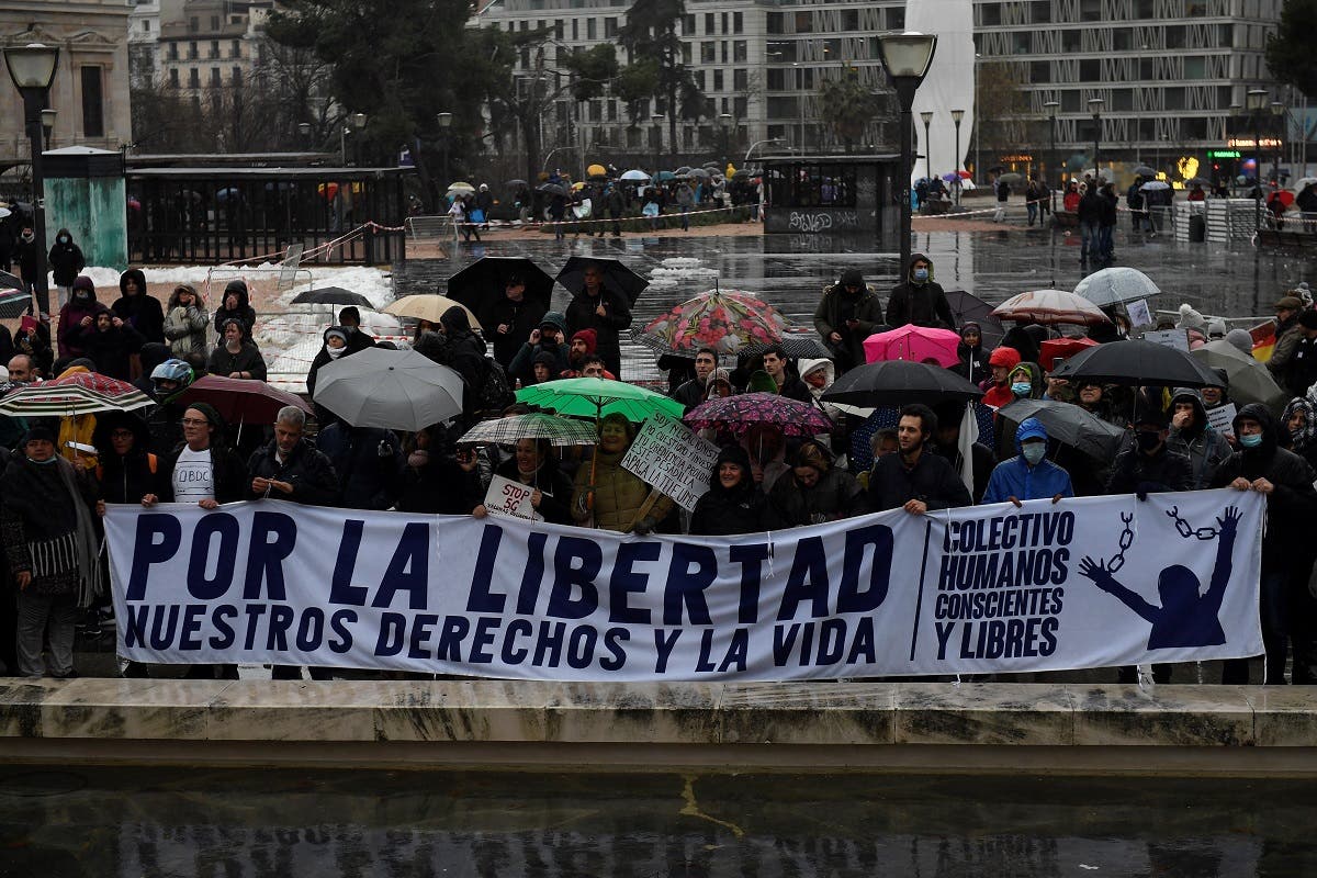 Demonstrators hold a banner reading “For the freedom of our rights and life” during a protest against coronavirus restrictions in Madrid on January 23, 2021. (Pierre-Philippe Marcou/AFP)