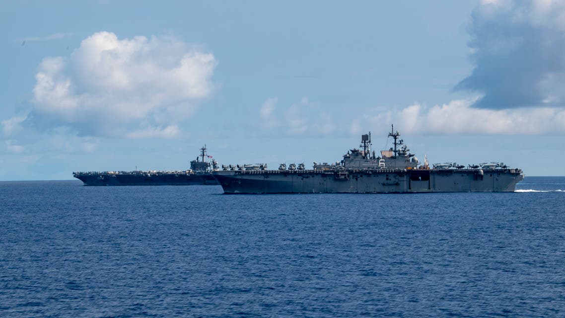 This US Navy handout photo obtained April 1, 2020 shows the Nimit-class aircraft carrier USS Theodore Roosevelt (CVN 71) and the America-class amphibious assault ship USS America (LHA 6) as they transit the Philippine Sea on March 24, 2020. The captain of the US nuclear-powered aircraft carrier Theodore Roosevelt told the Pentagon that new coronavirus is spreading uncontrollably through his ship and called for immediate help to quarantine its crew. But Defense Secretary Mark Esper on March 31, 2020 ruled out evacuating the ship, whose plight bears similarities to that on civilian cruise ships where the COVID-19 illness spread.