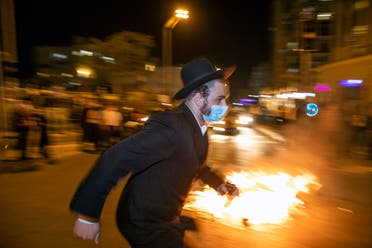  An Ultra-Orthodox Jewish man runs during a protest against lockdown put in place due to a coronavirus outbreak, in Jerusalem, Monday, July 13, 2020. (AP)