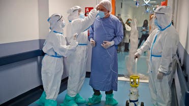 Giancarlo Vannimartini, an anesthetist who has been hospitalized for 10 days, is helped by medical personnel in the COVID-19 ward of the Ospedale dei Castelli Hospital in Ariccia, near Rome on Jan. 20, 2021. (AP)