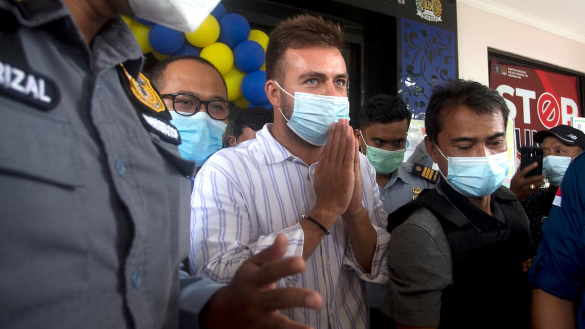 Russian citizen Sergei Kosenko, center, is escorted by Indonesian immigration officers at Immigration office in Nusa Dua, Bali, Indonesia on Sunday, Jan. 24, 2021. (AP)