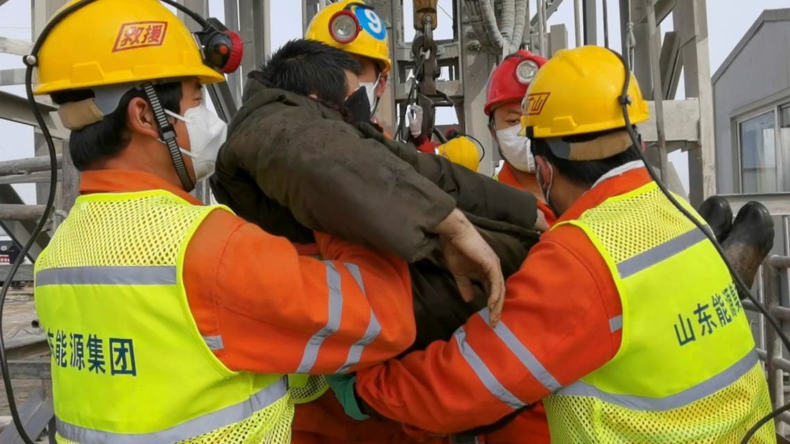 In this photo released by Xinhua News Agency, rescuers carry a miner who was trapped in a gold mine in Qixia City in east China's Shandong Province, Sunday, Jan. 24, 2021. Rescuers in China on Sunday lifted several trapped miners to the surface who were trapped for two weeks after an explosion in a northern gold mine, state media reported. (Luan Qincheng/Xinhua via AP)