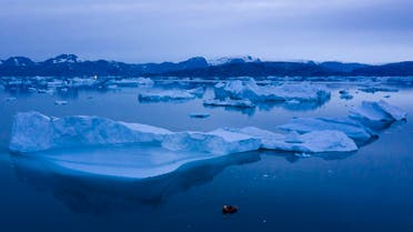 A boat navigates at night next to large icebergs near the town of Kulusuk, in eastern Greenland. (AP)