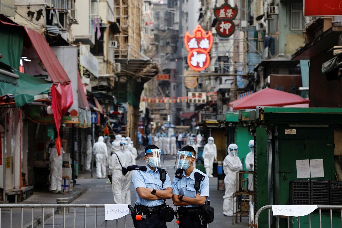 Police and health workers stand in protective gear inside a locked down portion of the Jordan residential area to contain a new outbreak of the coronavirus disease (COVID-19), in Hong Kong, China January 23, 2021. (Reuters)