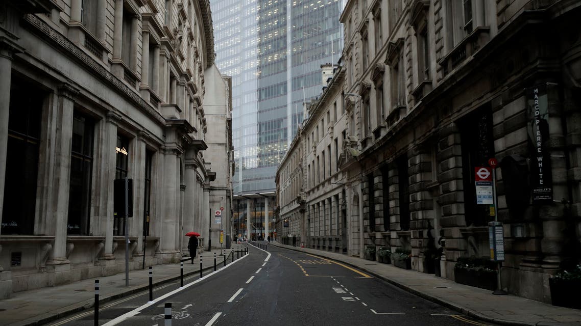 A person walks with an umbrella in light rain in the City of London financial district on the first morning of England entering a third national lockdown since the coronavirus outbreak began. (AP)