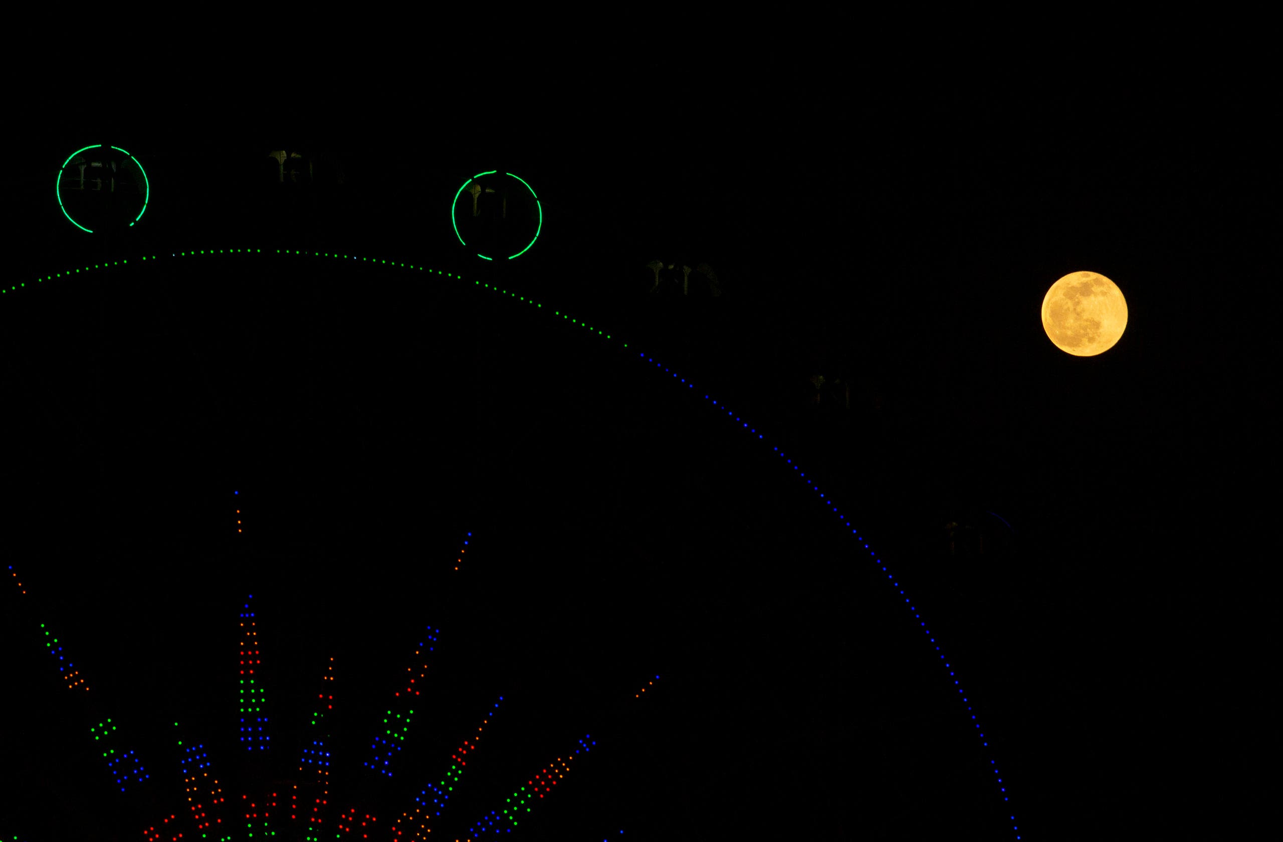 The full moon is pictured above a ferris wheel in the southern Iraq city of Basra on December 30, 2020. (AFP)