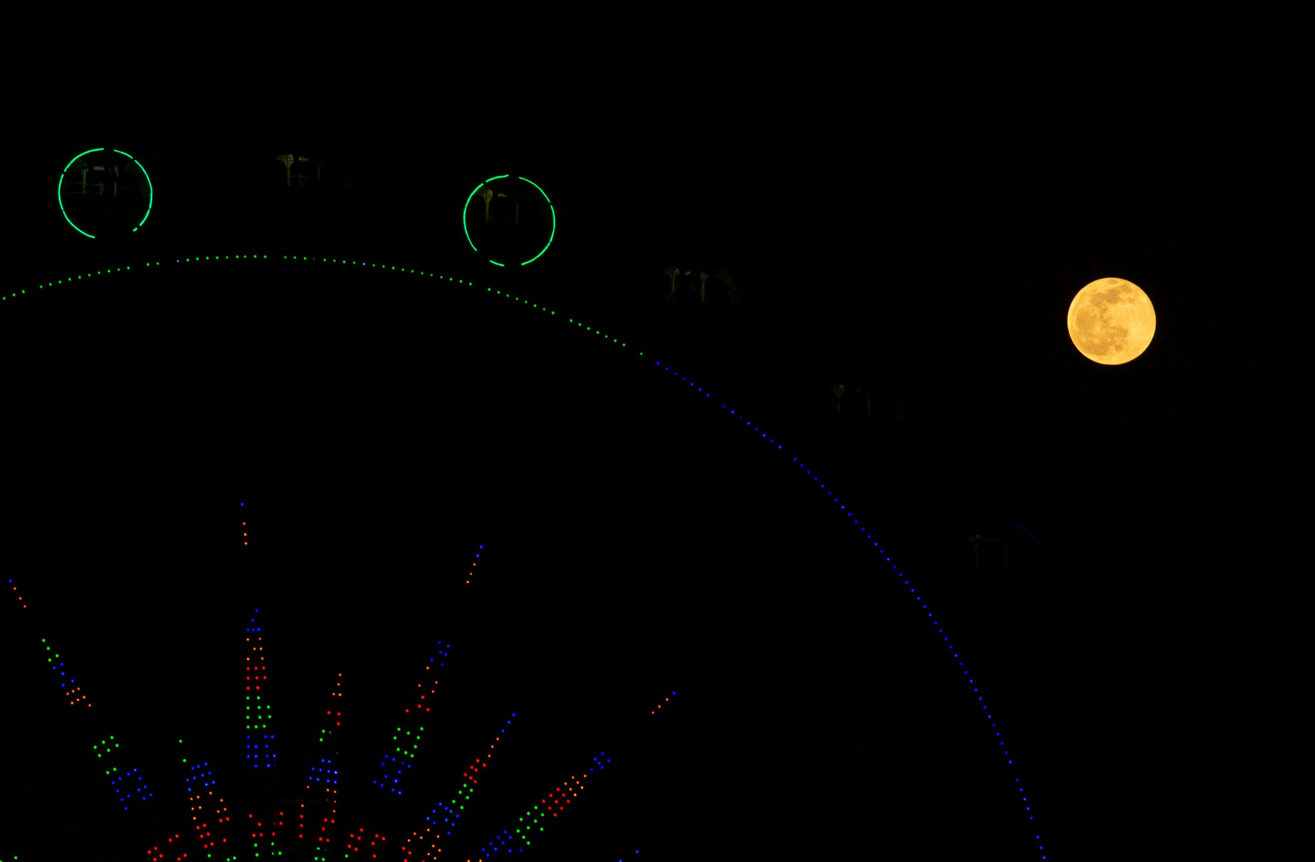 the full moon is pictured above a ferris wheel in the southern iraq city of basra on december 30, 2020. (afp)