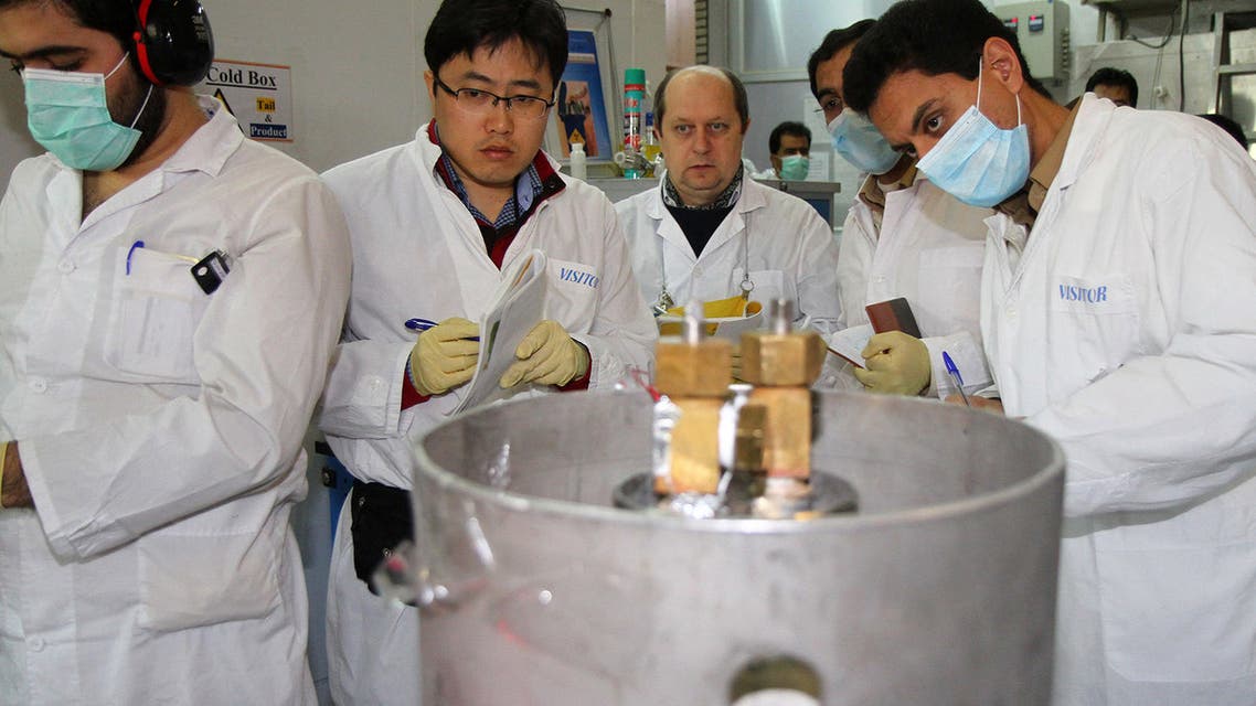 Unidentified International Atomic Energy Agency (IAEA) inspectors (2nd-3rd L) and Iranian technicians disconnect the connections between the twin cascades for 20 percent uranium production at nuclear research centre of Natanz, some 300 kilometres south of Tehran on January, 20, 2014 as Iran halted production of 20 percent enriched uranium, marking the coming into force of an interim deal with world powers on its disputed nuclear programme. AFP PHOTO/IRNA/KAZEM GHANE