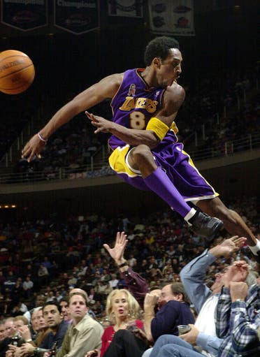 Kobe Bryant jumps over a row of fans after saving the ball from going out of bounds in the second half of the Lakers 107-101 win over the Houston Rockets Thursday, Dec. 20, 2001. (AP)