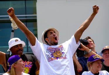 Kobe Bryant gestures to the crowd from atop a doubledecker bus as the Lakers victory parade arrives at Staples Center in Los Angeles, June 21, 2000. (AP)