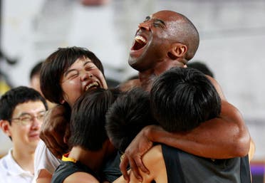 Kobe Bryant embraces South Korean students in his basketball clinic for youth in Seoul, South Korea. (AP)