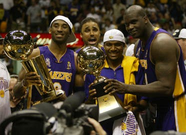 Los Angeles Lakers Kobe Bryant, left, holding the championship trophy, celebrates with teammates Rick Fox, Lindsey Hunter, second from right, and Shaquille O'Neal, right, holding the MVP trophy, after winning Game 4 of the NBA Finals, Wednesday, June 12, 2002, in East Rutherford, N.J. (AP)