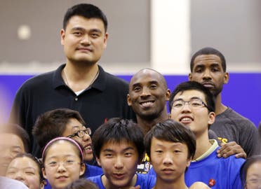 Kobe Bryant of the Los Angeles Lakers, top center, former NBA Houston Rockets basketball player Yao Ming, top left, pose with children during the NBA Cares Special Olympics Basketball Clinic in China. (AP)