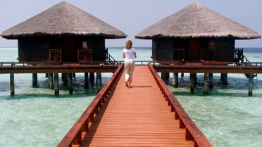 A resort employee walks along the walkway of the Baros Island resort  in the Maldives. AP