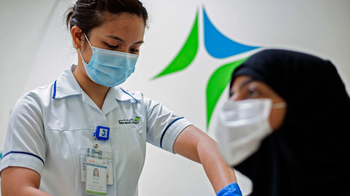 A handout picture taken by the Government of Dubai Media Office on December 23, 2020, shows a health worker administering a dose of the coronavirus vaccine at a medical center in the Dubai Emirate. (AFP)