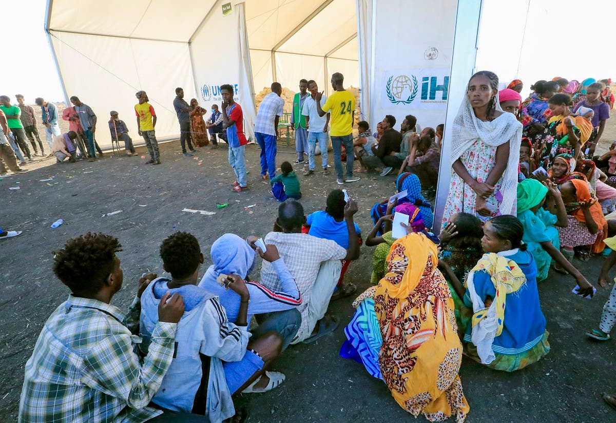 Ethiopian refugees, who fled the Tigray conflict, gather to receive aid at the Tenedba camp in Mafaza, eastern Sudan on January 8, 2021, upon their arrival at the camp from the reception center. (AFP)