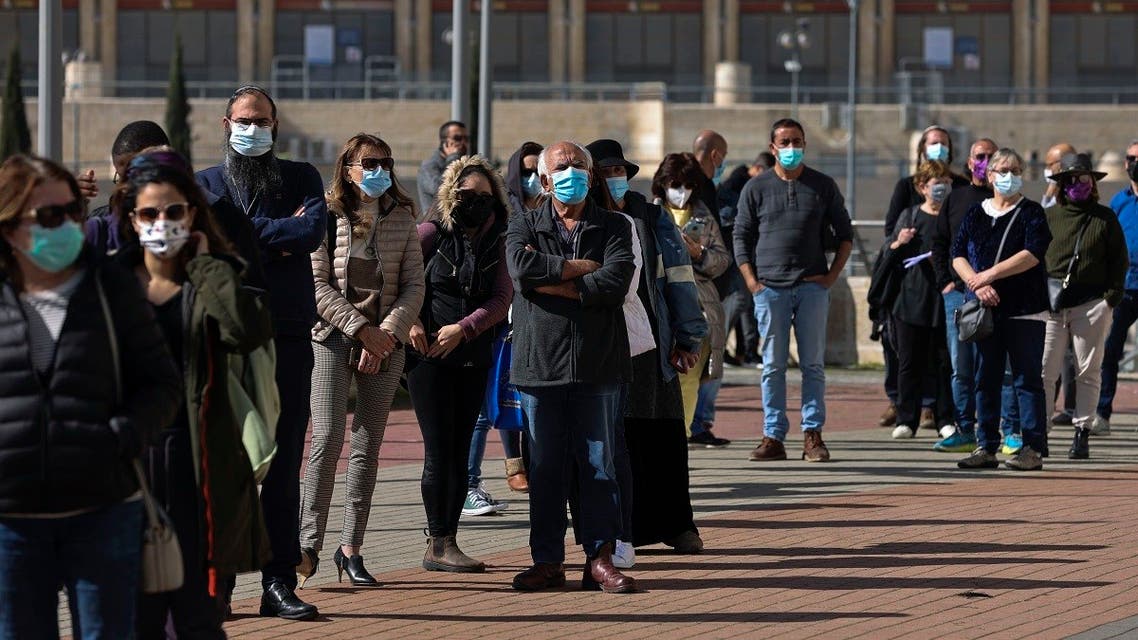 People wait in queue to receive a dose of the Pfizer-BioNtech COVID-19 vaccine at Clalit Health Services in Jerusalem, on January 24, 2021. (Menahem Kahana/AFP)