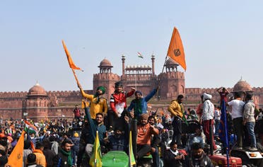 Sikhs hoist a Nishan Sahib, a Sikh religious flag, on a minaret of the historic Red Fort monument in New Delhi, India, Tuesday, Jan. 26, 2021. (AP)