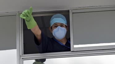 A doctor gives a thumb up during the novel coronavirus COVID-19 pandemic, at the emergency door of the Carlos Andrade Marin Hospital in Quito, on April 18, 2020. (AFP)