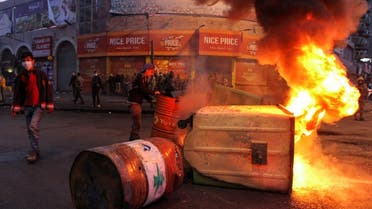 Garbage bins, set on fire by demonstrators, block a road during a protest against the lockdown and worsening economic conditions in Tripoli, Lebanon Jan. 26, 2021. (Reuters)