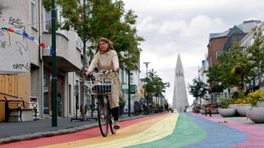 A woman cycles down a street painted in rainbow colours near the Hallgrimskirkja church, as the outbreak of the coronavirus disease (COVID-19) continues, in Reykjavik. (Reuters)
