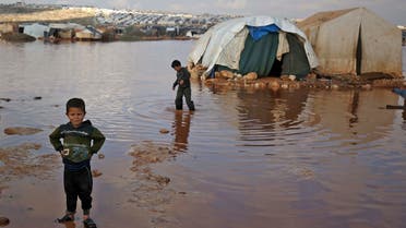Syrian children play among flooded tents at a camp for displaced Syrians near the town of Kafr Lusin by the border with Turkey, Jan. 19, 2021. (AFP)